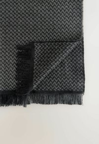 Gray herringbone-patterned blanket with fringed edges, made from soft material, featuring alternating black and light gray tones.