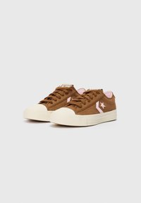 Brown corduroy sneakers with a cream rubber toe cap, pink accents, and matching interior. Features flat laces and a textured sole.