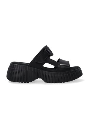 Sorte sandaler med en tyk, ribbet sål og en glat overdel. Har brede stropper og en spænde i siden til justering. Blød, tekstureret finish.