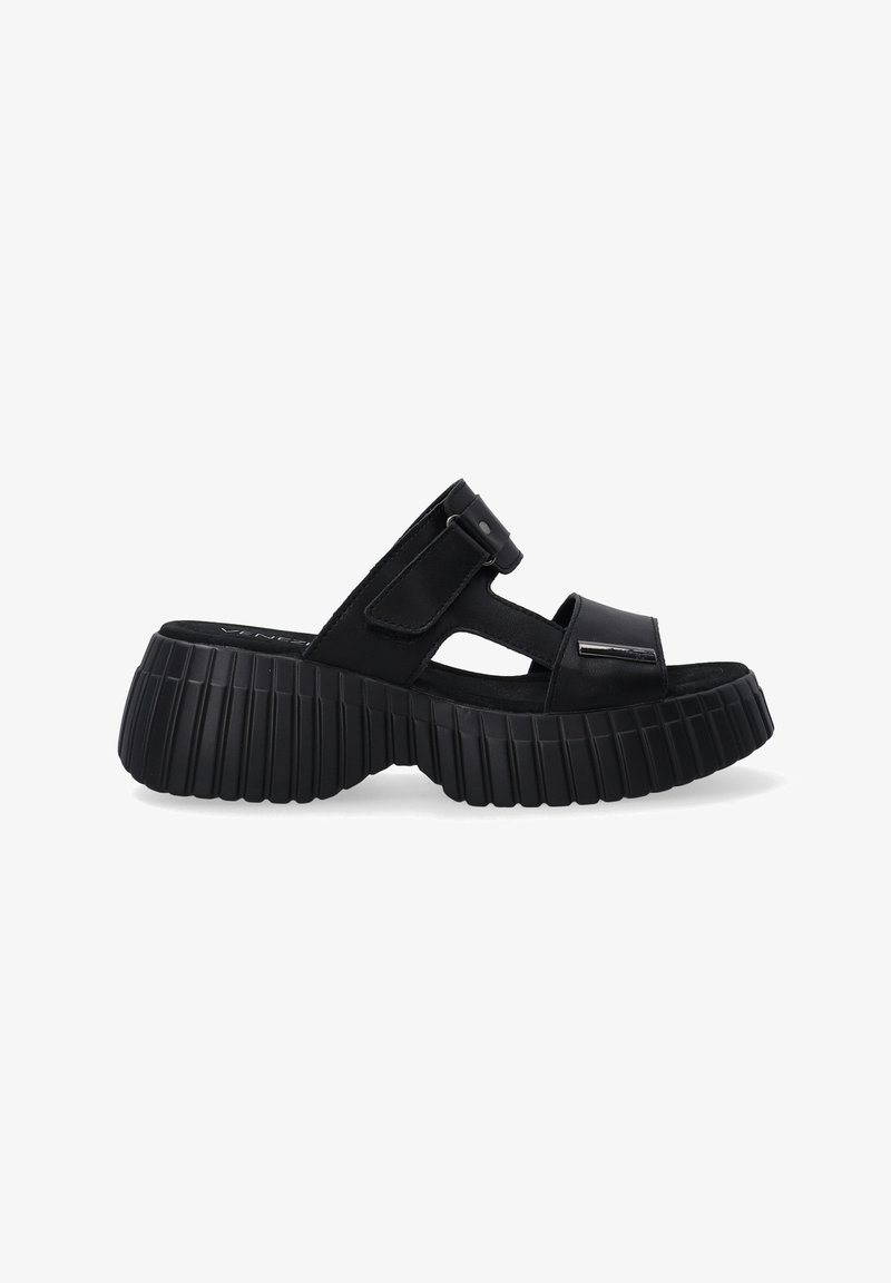 Černé sandály s tlustou, vroubkovanou podrážkou a hladkým svrškem. Mají široké pásky a boční přezku pro nastavení. Měkký, strukturovaný povrch.