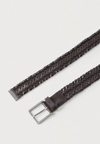 Καφέ πλεξούδα δερμάτινη ζώνη με ασημένια μεταλλική αγκράφα. Διαθέτει λείο δερμάτινο διακοσμητικό κοντά στην αγκράφα. Υφή με υφαντό μοτίβο.