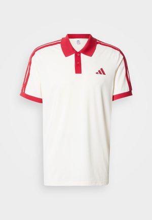 Wit poloshirt met rode kraag en accenten aan de mouwen. Heeft drie rode strepen langs elke schouder en een rood driehoekig logo op de borst.