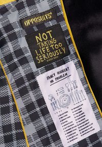 Tela con un diseño en negro y gris con un borde amarillo, que presenta dos etiquetas: una con texto amarillo y otra con ilustraciones de utensilios de mesa y palabras.