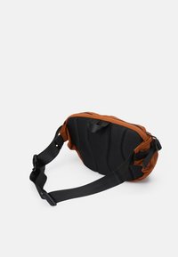 Bruine en zwarte slingbag met een gevoerde mesh achterkant, verstelbare schouderband en dubbele ritscompartimenten. Lichtgewicht, compact ontwerp voor gebruiksgemak.