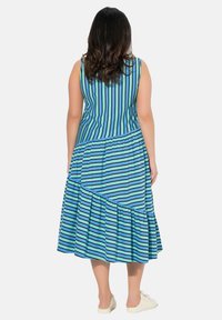 Blå och grön randig klänning med en åtsittande överdel och en flödande, lagd kjol. Slät tyg med en avslappnad stil och rund halsringning.