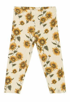 Leggings beige clair avec un motif de tournesols, présentant des tournesols jaunes et verts. Confectionnés en tissu doux et extensible pour un maximum de confort.