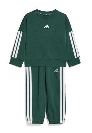 Tummanvihreä Adidas-taaperopuku, jossa valkoiset kolmoisraidat hihoissa ja housuissa, Adidaksen logo rinnassa ja vasemman lahkeen kohdalla.