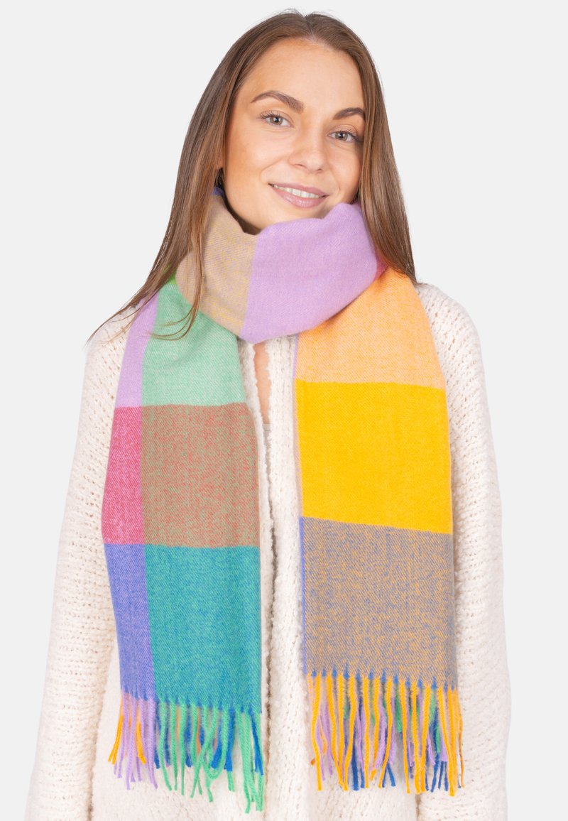 Écharpe multicolore présentant un motif à carreaux dans des teintes pastel de vert, violet, jaune et orange, avec des bords frangés et une texture douce.