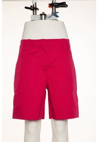 Pantalones cortos magenta con un corte ajustado, fabricados en tela ligera. Cuenta con bolsillos frontales y un dobladillo recto. Sin adornos visibles.