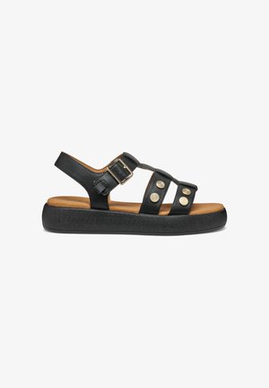 Sandale en cuir noir avec trois brides, boucle dorée, clous ronds décoratifs en métal et semelle épaisse noire rembourrée.