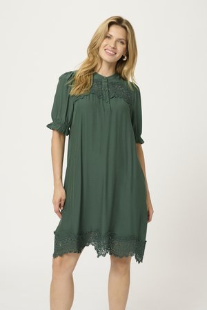 Rochie verde dintr-un material moale, cu guler cu nasturi, mâneci bufante și un tiv decorativ din dantelă.