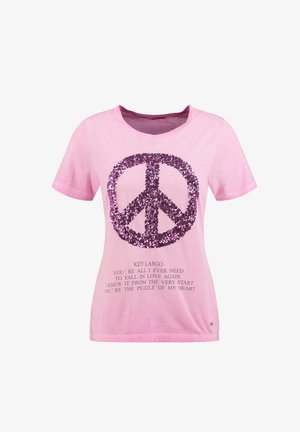 Chemise rose à manches courtes avec un grand symbole de paix en paillettes violettes et un texte sur l'amour et Key Largo imprimé sous le symbole.