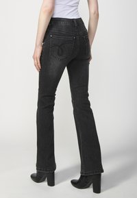 Koroshi FLARED - Pieguloša piegriezuma džinsi - black denim