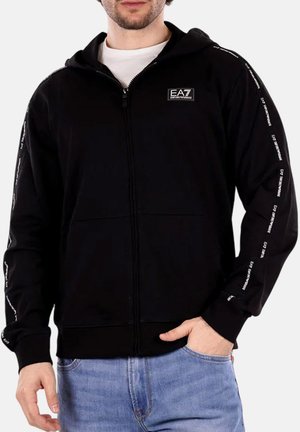 Felpa nera con zip realizzata in tessuto morbido, dotata di cappuccio, due tasche anteriori e accenti di testo bianco lungo le maniche.