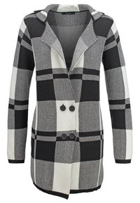 Gilet long à carreaux noir et blanc en tissu maille texturé, avec un col à revers et de gros boutons noirs sur le devant.