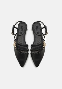 Black leather slingback shoes with pointed toe, multiple slender straps, gold hardware accents, and textured black insole.