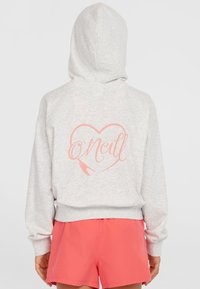 Grå hættebluse med et hjertegrafik i pink på ryggen, med snoretræk til hætten og ribbede manchetter, parret med pink shorts.
