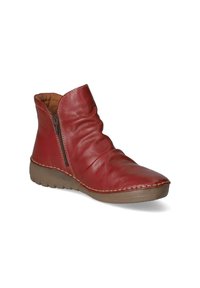 Bottine en cuir rouge avec fermeture éclair latérale, tige froncée, couture beige et semelle en caoutchouc marron.
