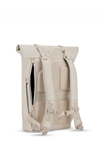 Beige színű roll-top hátizsák párnázott, hálós hátrésze, állítható vállpántjai és oldalsó cipzárja van a könnyű hozzáférés érdekében. Simább, tartós anyag, minimális részletezéssel.