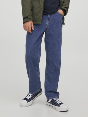 Blaue Jeans aus Denim mit geradem Schnitt, ausgestattet mit Kontrastnähten und einem klassischen Fünf-Taschen-Design, kombiniert mit marineblauen Turnschuhen.