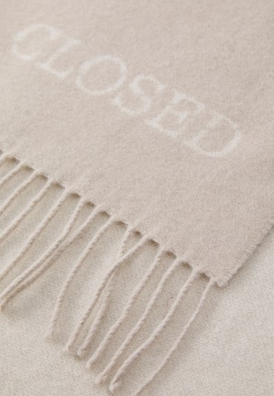 Sciarpa di lana beige con la parola "CLOSED" in un testo più chiaro, bordi frangiati e una texture morbida. Dettagli della superficie liscia visibili.