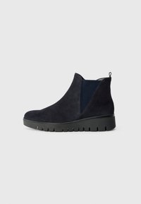Botas de tobillo de ante azul marino que cuentan con paneles laterales de malla y una suela de plataforma de goma negra con surcos horizontales. Lengüeta en la parte posterior para ponerlas y quitarlas con facilidad.