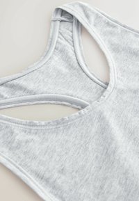Lys grå tanktop i blødt stof med en rund halsudskæring og krydsede stropper bagpå. Glat tekstur med en subtil meleret mønster.