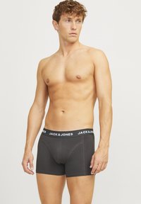 Boxers noirs avec une large ceinture élastique affichant "JACK & JONES" en blanc. Le tissu semble doux et ajusté, adapté à un usage quotidien.