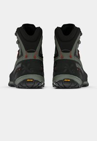 Mustad mustarakud, hallid jalatsid, kõrge kaelusega, tekstuurse pinnaga, punaste aktsentidega ning Vibram tallaga haardeks. Tagumine perspektiivivaade.