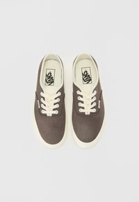 Mørkegrå canvas-sneakers med hvite gummisåler og snørebånd. Har et lite logomerke på siden og en polstret indre krave.