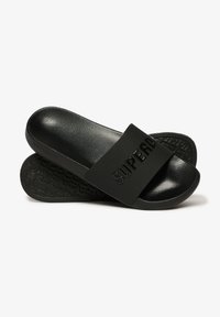 Zwarte slide-sandalen met een brede band met "SUPERDRY" erop geperst, een gestructureerde zool, glad materiaal en een minimalistisch ontwerp.