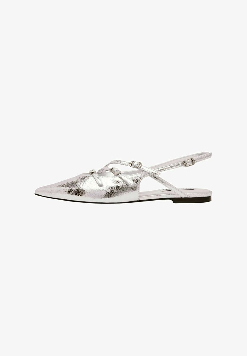 Ballerine slingback in argento metallico con punta affusolata. Presenta cinturini incrociati e suola piatta. Texture liscia con una leggera lucentezza.