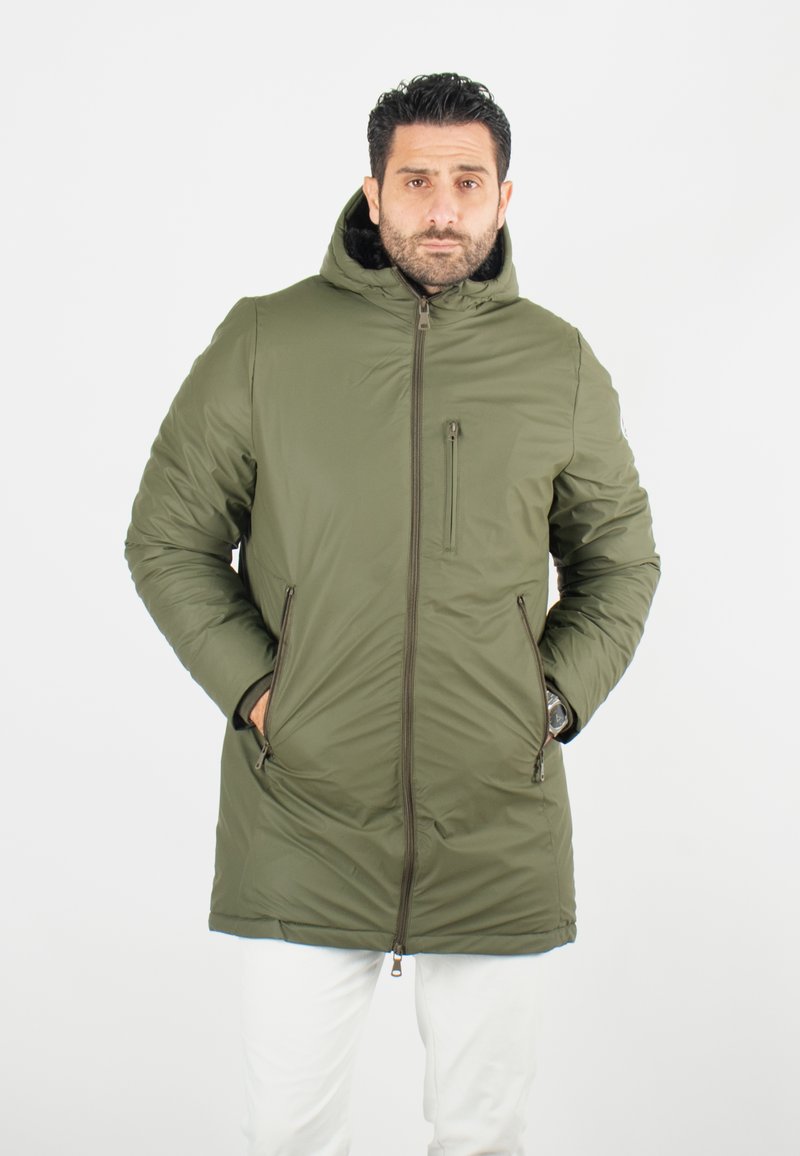 Veste matelassée vert olive avec capuche, fermeture éclair sur le devant, poches latérales et poche poitrine. Offre une texture lisse et une isolation chaude.