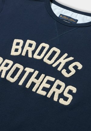 Marine sweatshirts met crèmekleurige gebreide letters "BROOKS BROTHERS". Ribbelkraag en stikdetails zijn zichtbaar. Zachte stofstructuur.