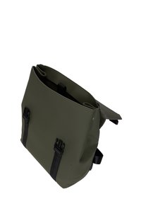 Grön vattentät väska med en strukturerad form, utrustad med två svarta spännen, sidostraps och en slät, matt yta.