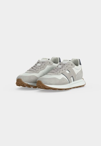 Paire de baskets de sport gris clair et blanc avec des détails en daim, fermeture à lacets à l'avant et semelles en caoutchouc marron sur fond blanc.