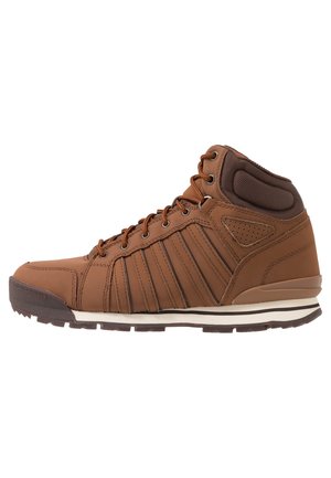 Brązowy wysoki sneaker z wyściełanym kołnierzem, sznurowany z przodu, z pionowymi przeszyciami oraz białą śródstopą z ciemnobrązową podeszwą zewnętrzną.