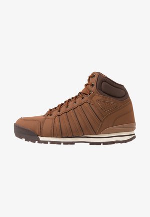Sneaker marrone alta con collo imbottito, chiusura frontale con lacci, dettagli con cuciture verticali e intersuola bianca con suola esterna marrone scuro.