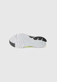 Semelle de sneaker blanche avec des accents en caoutchouc noir texturé. Présente un motif en vagues et un logo de marque visible. Design léger adapté aux sports.