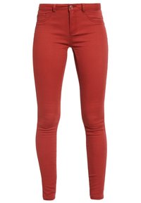 Czerwone skinny jeans z gładką fakturą, szlufkami na pasek i kieszeniami z przodu. Posiadają pojedynczy guzik oraz zamek błyskawiczny.