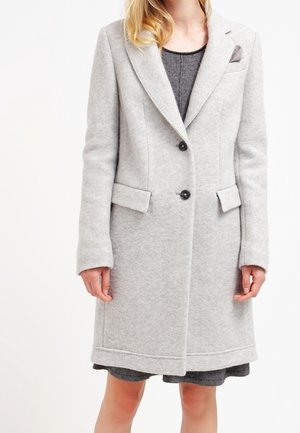 Cappotto in lana grigio chiaro con rever a lancia, due tasche frontali e una chiusura con un solo bottone. Texture morbida con dettagli di cuciture sottili.