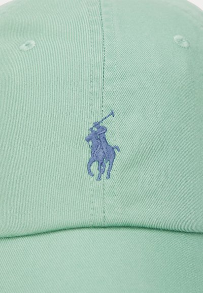 Light green cap made of cotton with an embroidered purple polo player logo on the front. Features stitched ventilation holes.