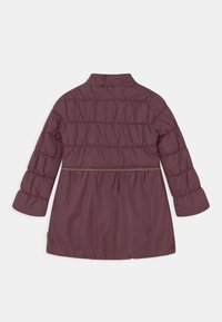 Veste violette matelassée, avec un col montant, des manches longues, une taille élastique et des coutures horizontales pour la texture. Extérieur lisse et brillant.
