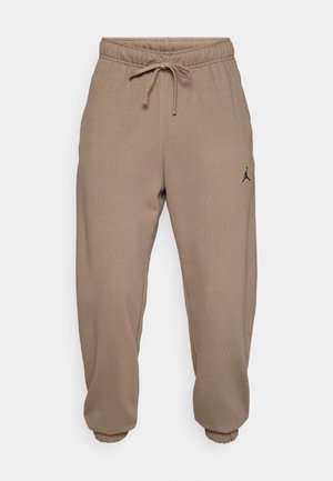 Smeđe trenirke s elastičnom sredinom i podesivim vezicama. Imaju manžete na gležnjevima i mali crni logotip na lijevoj nozi.