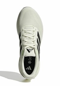 Zapato deportivo blanco con parte superior de malla, diseño de tres franjas negras, acentos verdes, cordones planos y plantilla acolchada.
