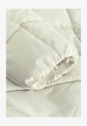 Hellbeige, gesteppte Decke mit einer glatten, weichen Textur. Verfügt über eine elastische, geraffte Öffnung und eine flache, unverzierte Oberfläche.