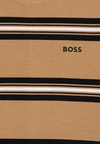 Pruun kangast T-särk horisontaalsete triipudega musta, valge ja kreemi värviga. Ees on must "BOSS" logo. Pehme tekstuur.