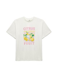 T-shirt en coton blanc avec un graphisme coloré représentant des citrons et des feuilles, avec le texte "CITRUS FRUIT" et un fond à carreaux roses.