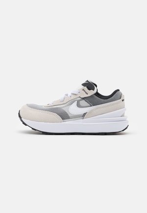 Lavtop Nike sneaker i grå, beige og hvid med mesh og ruskindspaneler, hvid swoosh, hvide snørebånd og tyk hvid sål med sort mønster.