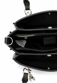 Juodos odos rankinė su trimis skyreliais. Turi užtrauktukus ir spaudžiamus užsegimus. Vidus išklotas juoda medžiaga, yra mažytė kišenėlė.